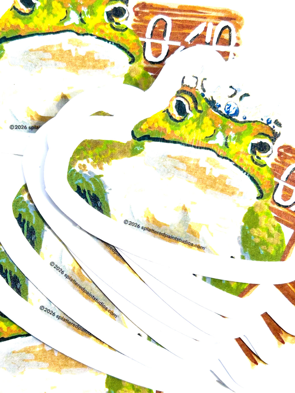 Stack of 0/10 vinyl stickers featuring a crowned frog holding a rating sign