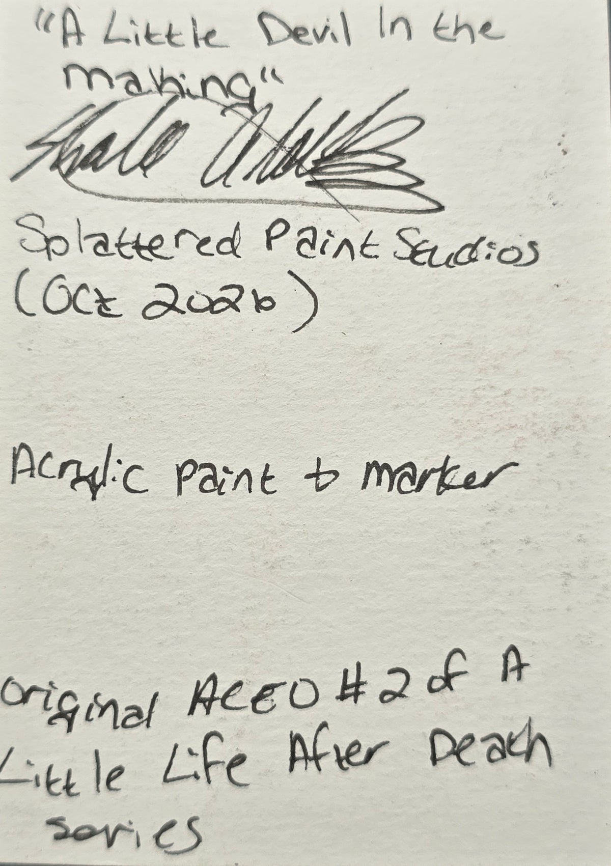 Reverse side of A Little Devil in the Making original ACEO showing the handwritten title, artist signature, acrylic paint and marker medium, and Splattered Paint Studios information.