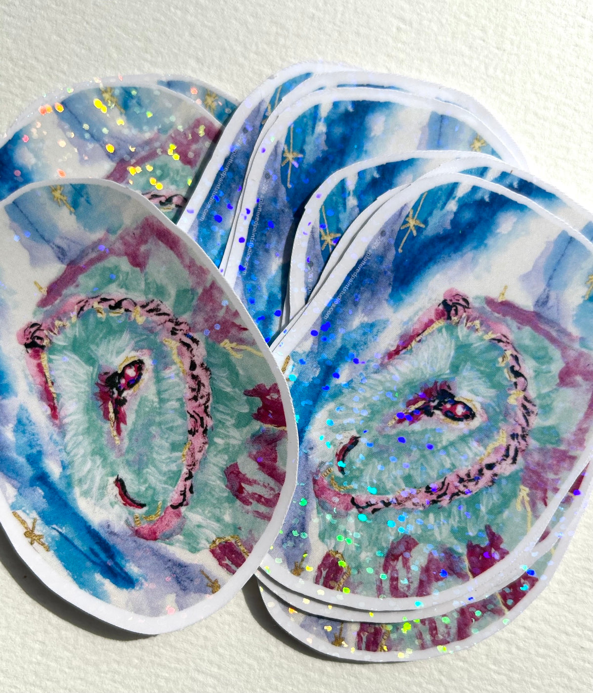 Group of Astral Owl holographic vinyl stickers featuring a turquoise and pink owl with sparkling rainbow details