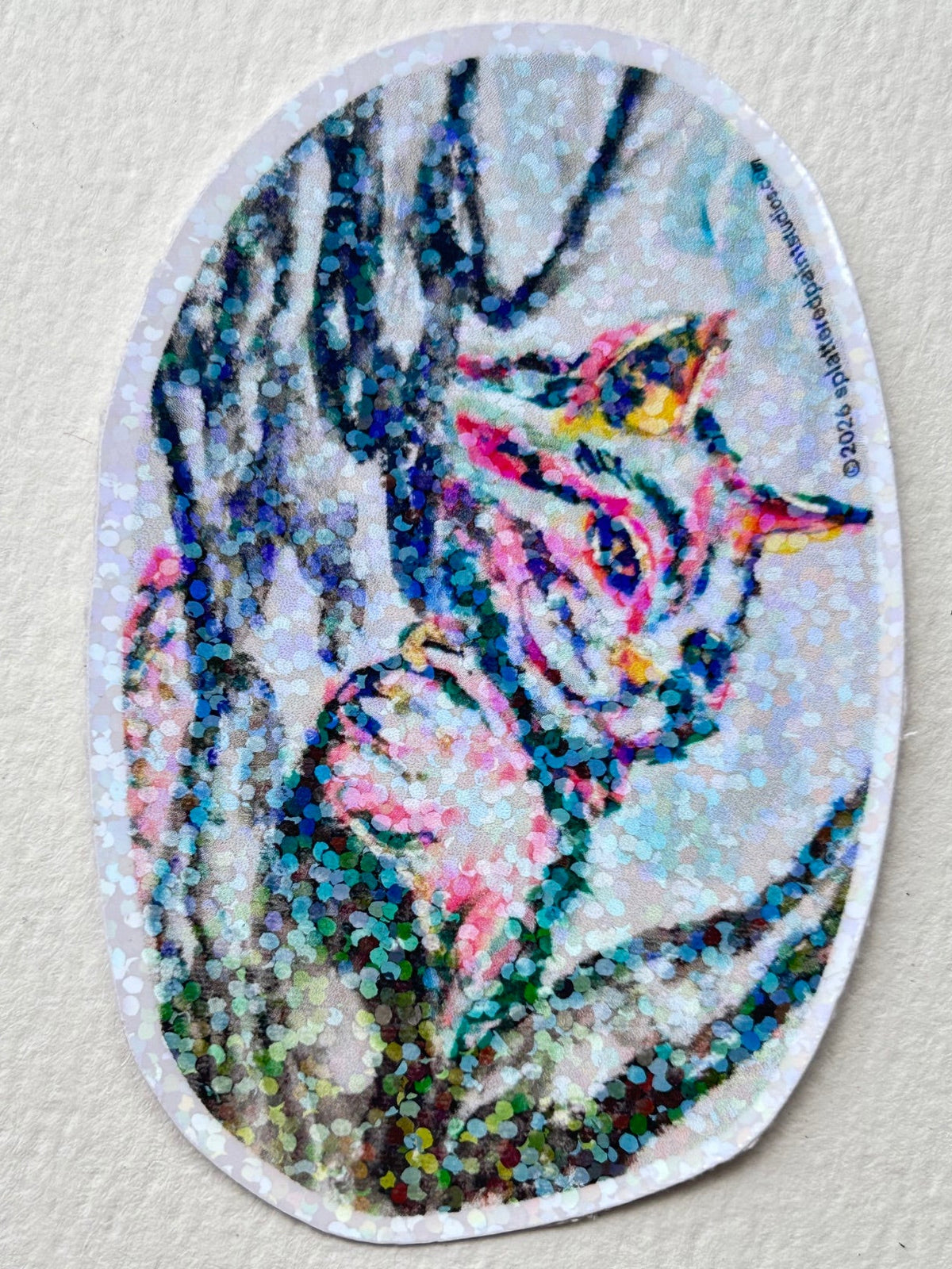 Between The Branches 3-inch vinyl sticker featuring a colorful cat nestled among tree branches