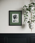 Breath of Light 5x7 charcoal art print with gold accents displayed in a black frame with green matting