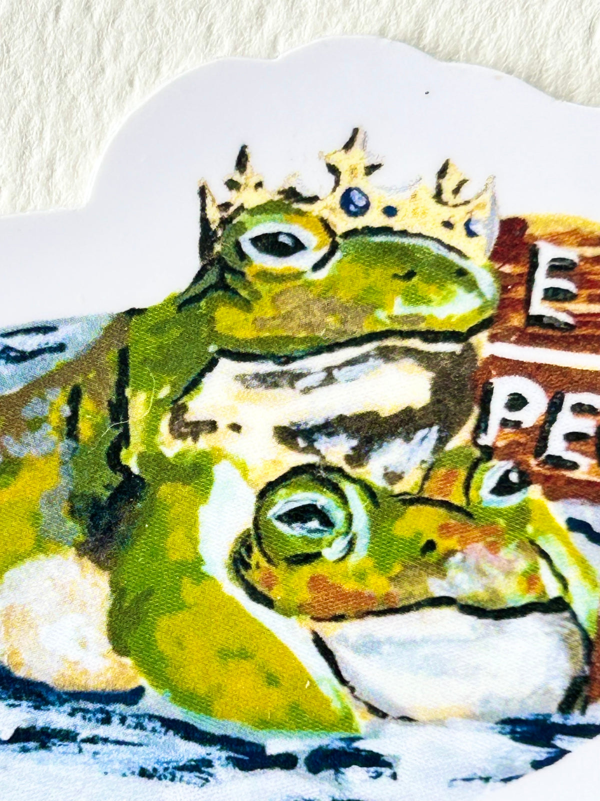 Close-up of Ew...People vinyl sticker showing two expressive green frogs, including one wearing a crown