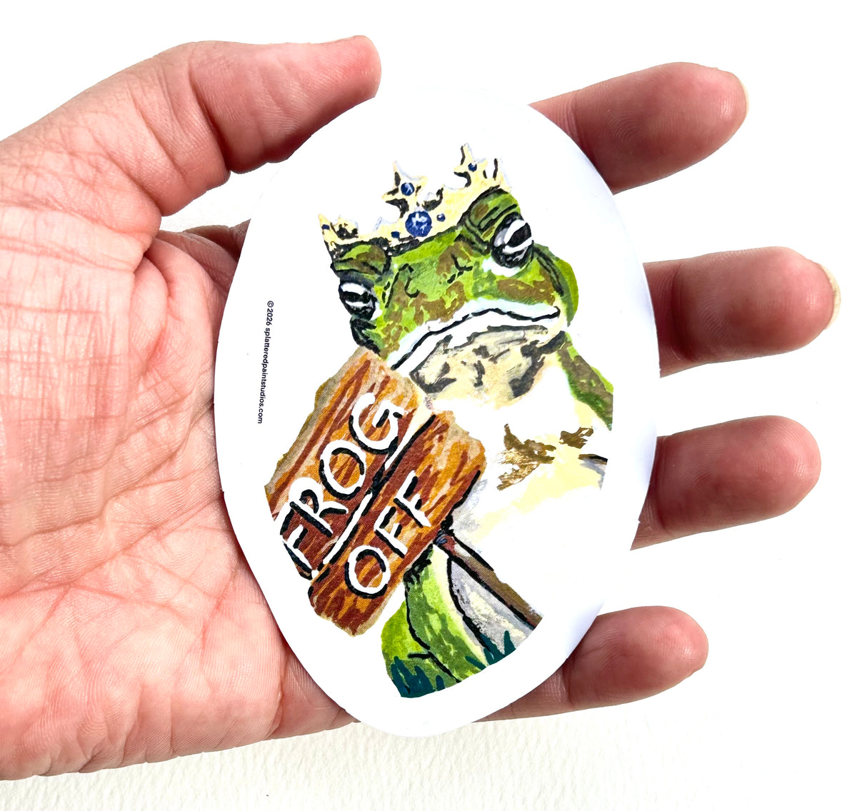 Frog Off 3-inch vinyl sticker held in hand to show size and scale