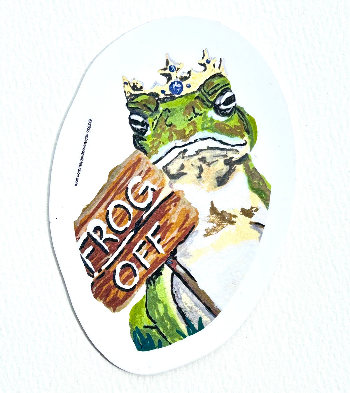 Frog Off 3-inch vinyl sticker featuring a crowned green frog holding a wooden Frog Off sign