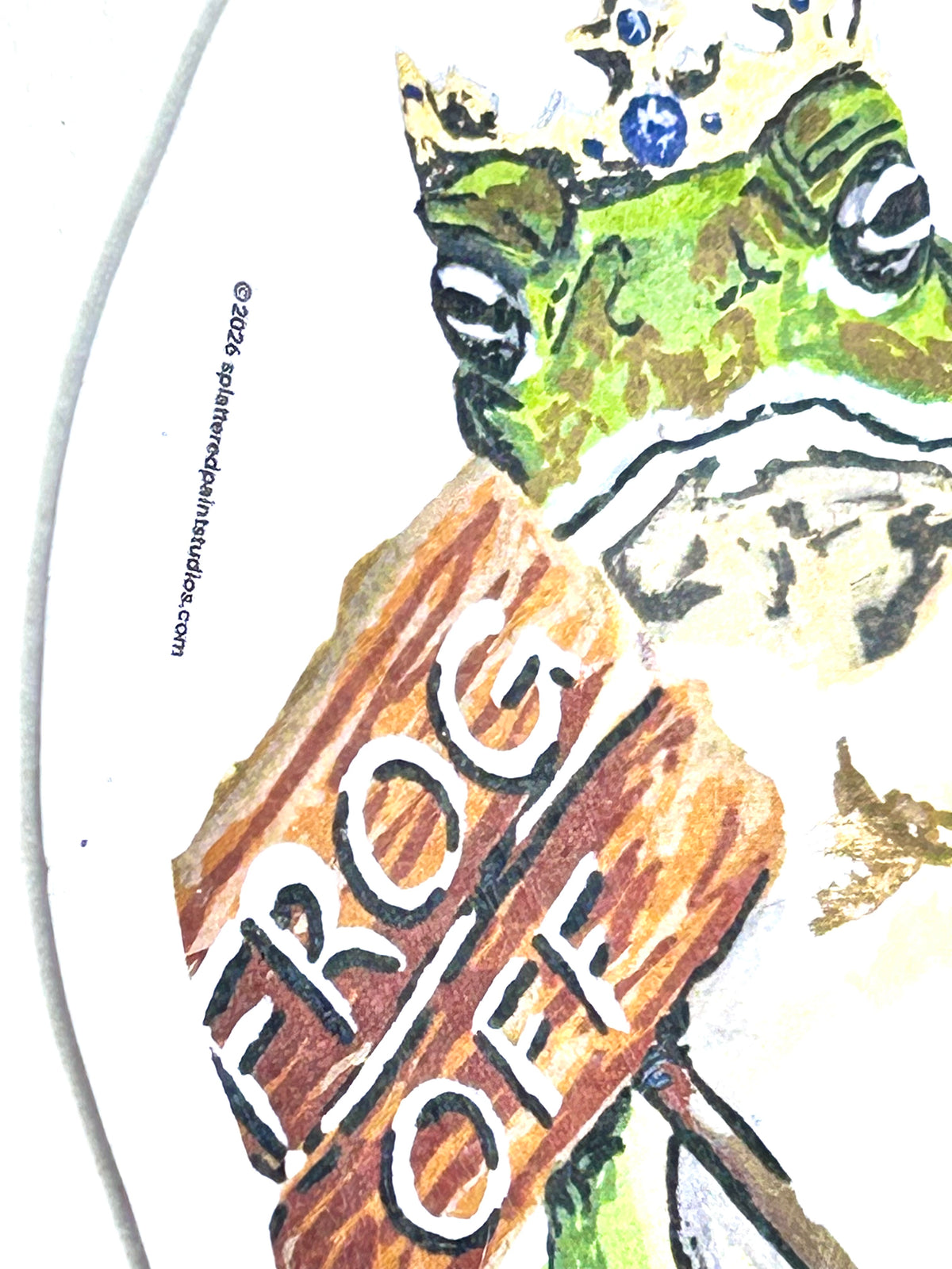 Close-up of Frog Off vinyl sticker showing the crowned frog and hand-painted Frog Off wooden sign