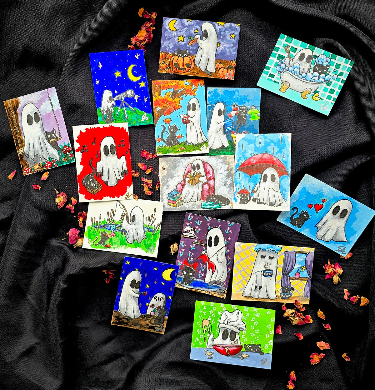 Photograph of the Ghost & Kitty Collection by Splattered Paint Studios, featuring 15 original miniature ACEO paintings of a white ghost and black cat enjoying whimsical adventures.