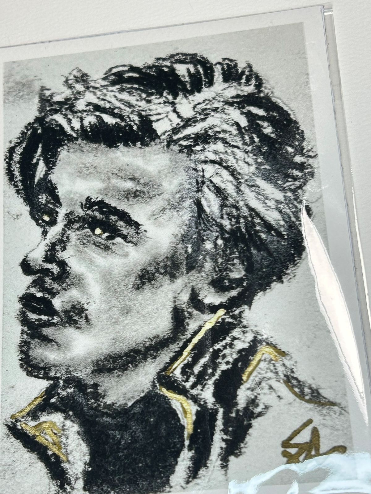 Close-up of Golden Gaze charcoal portrait print showing expressive black charcoal marks and gold accents