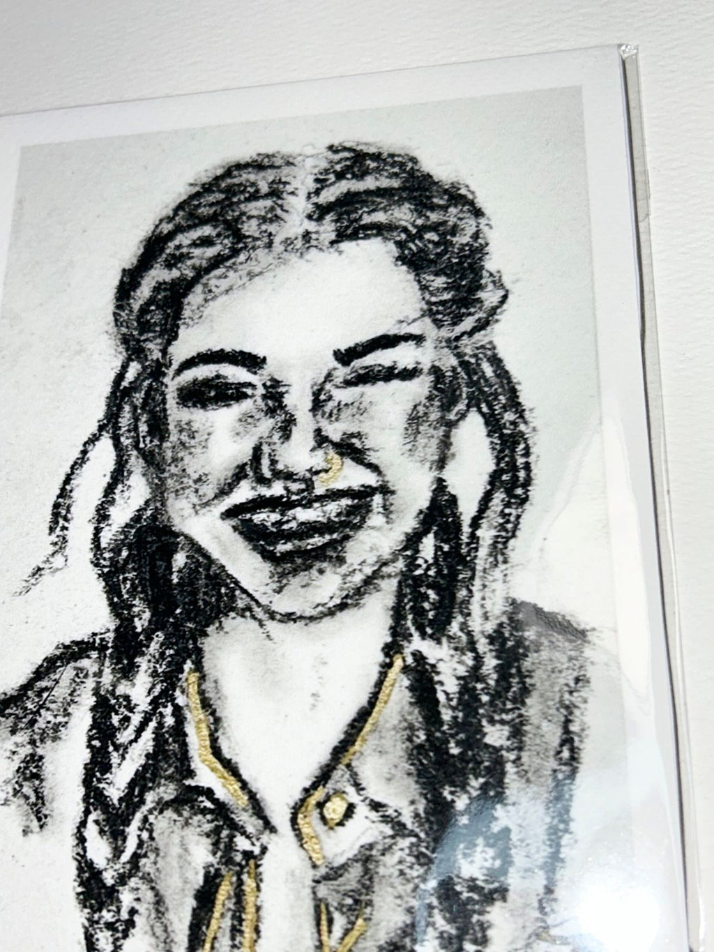 Close-up of Golden Gaze charcoal portrait print showing expressive black charcoal marks and gold accents
