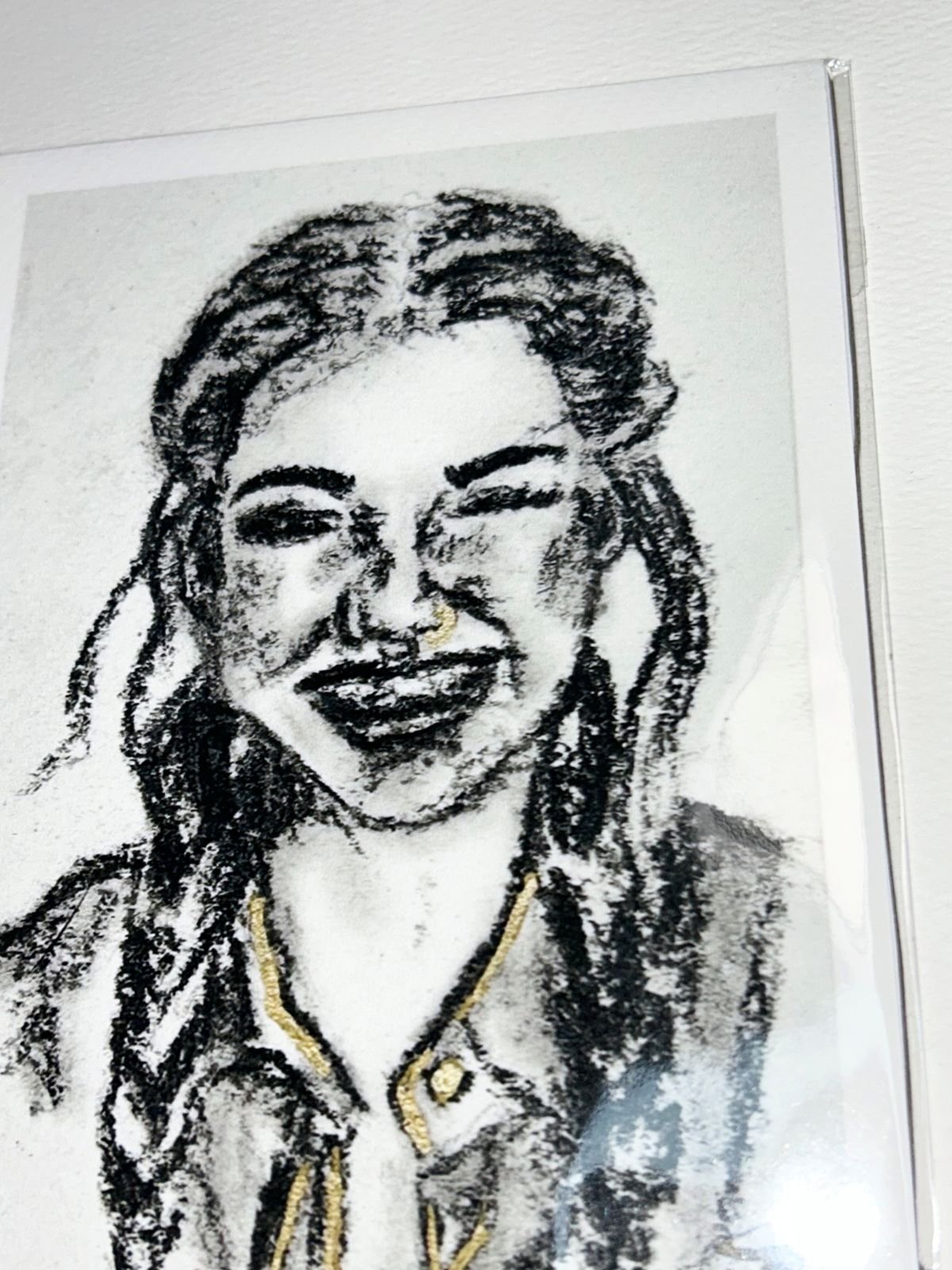 Close-up of Golden Gaze charcoal portrait print showing expressive black charcoal marks and gold accents