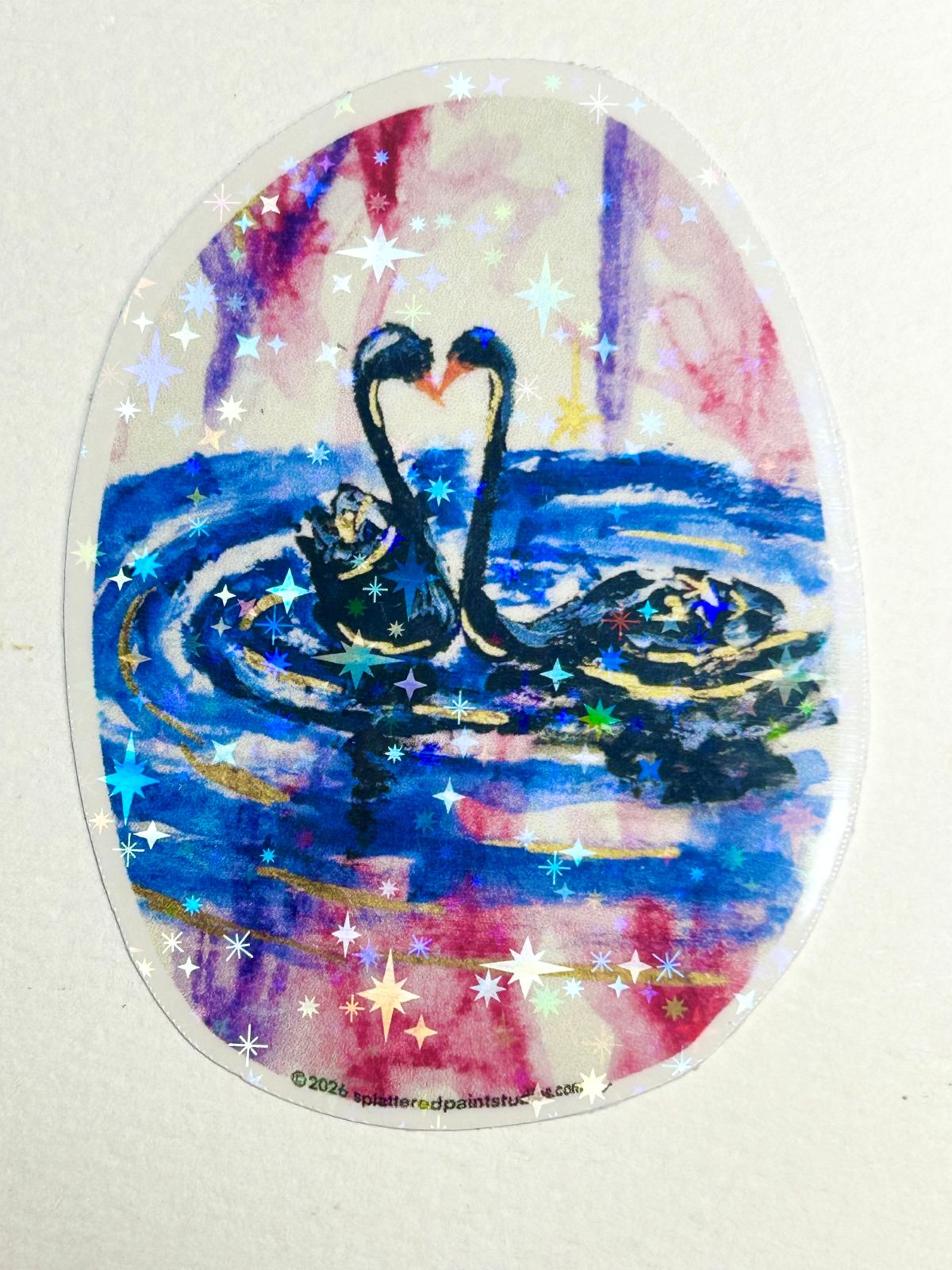Heart of the Cosmos holographic vinyl sticker featuring two swans forming a heart surrounded by colorful stars