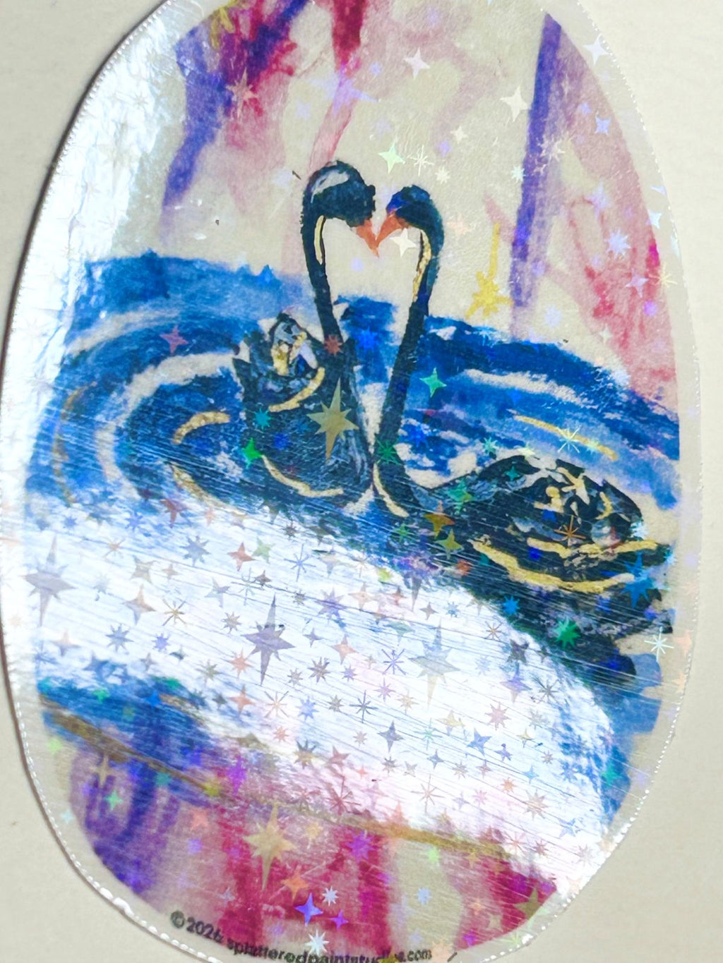 Heart of the Cosmos vinyl sticker angled to show the reflective holographic star laminate over the swan artwork