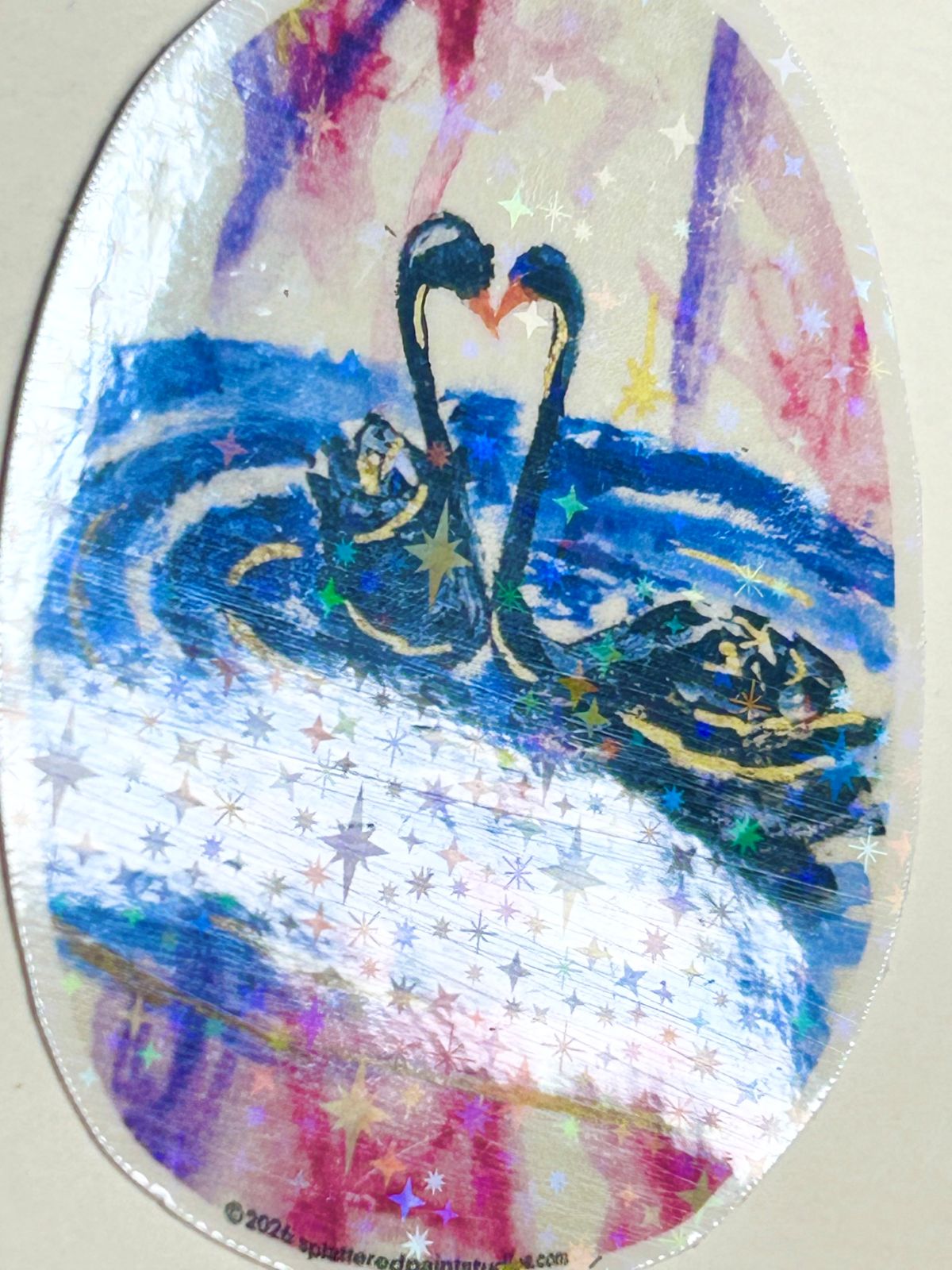 Heart of the Cosmos vinyl sticker angled to show the reflective holographic star laminate over the swan artwork