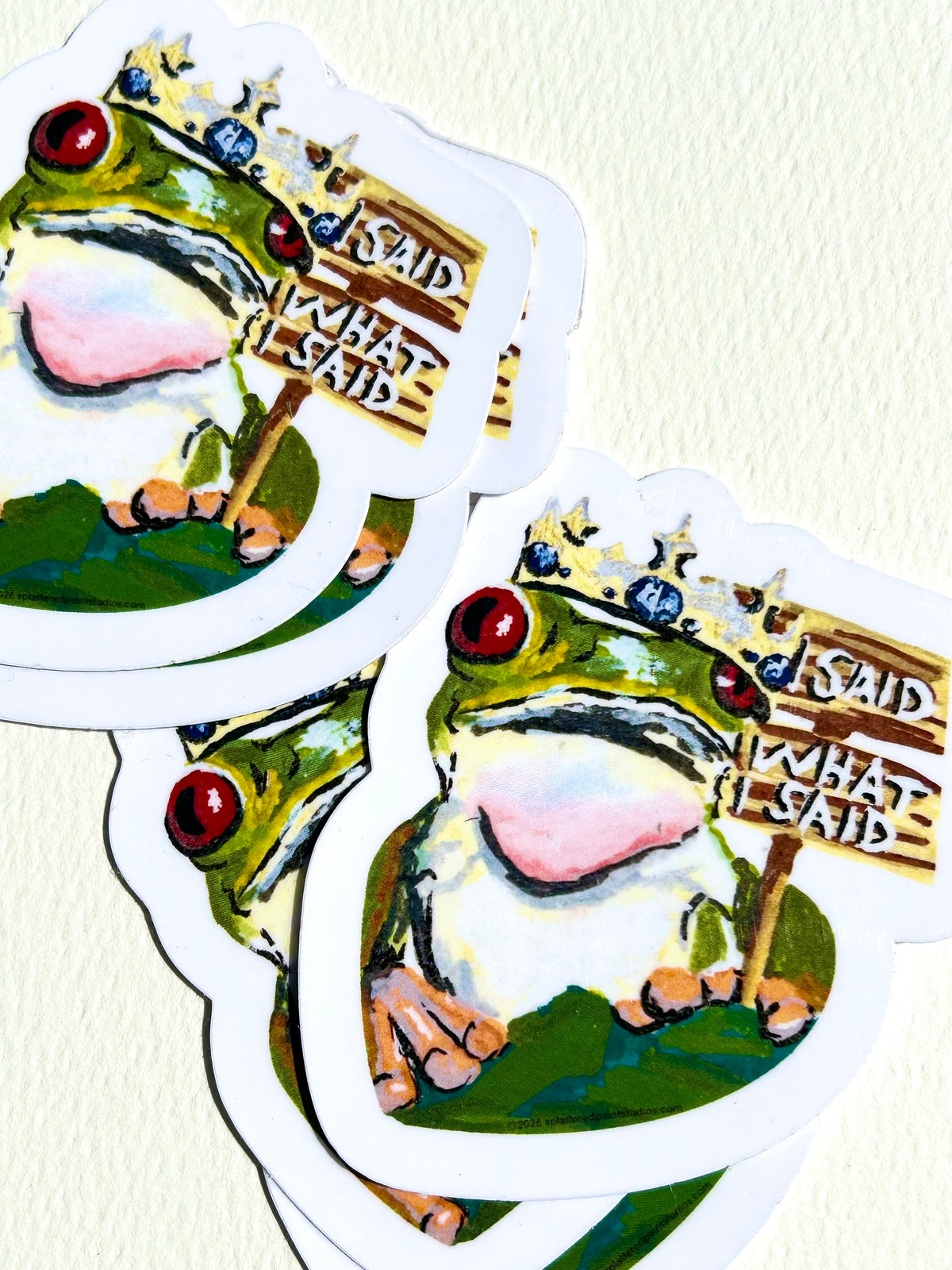 Stack of I Said What I Said vinyl stickers featuring a crowned frog holding a humorous sign