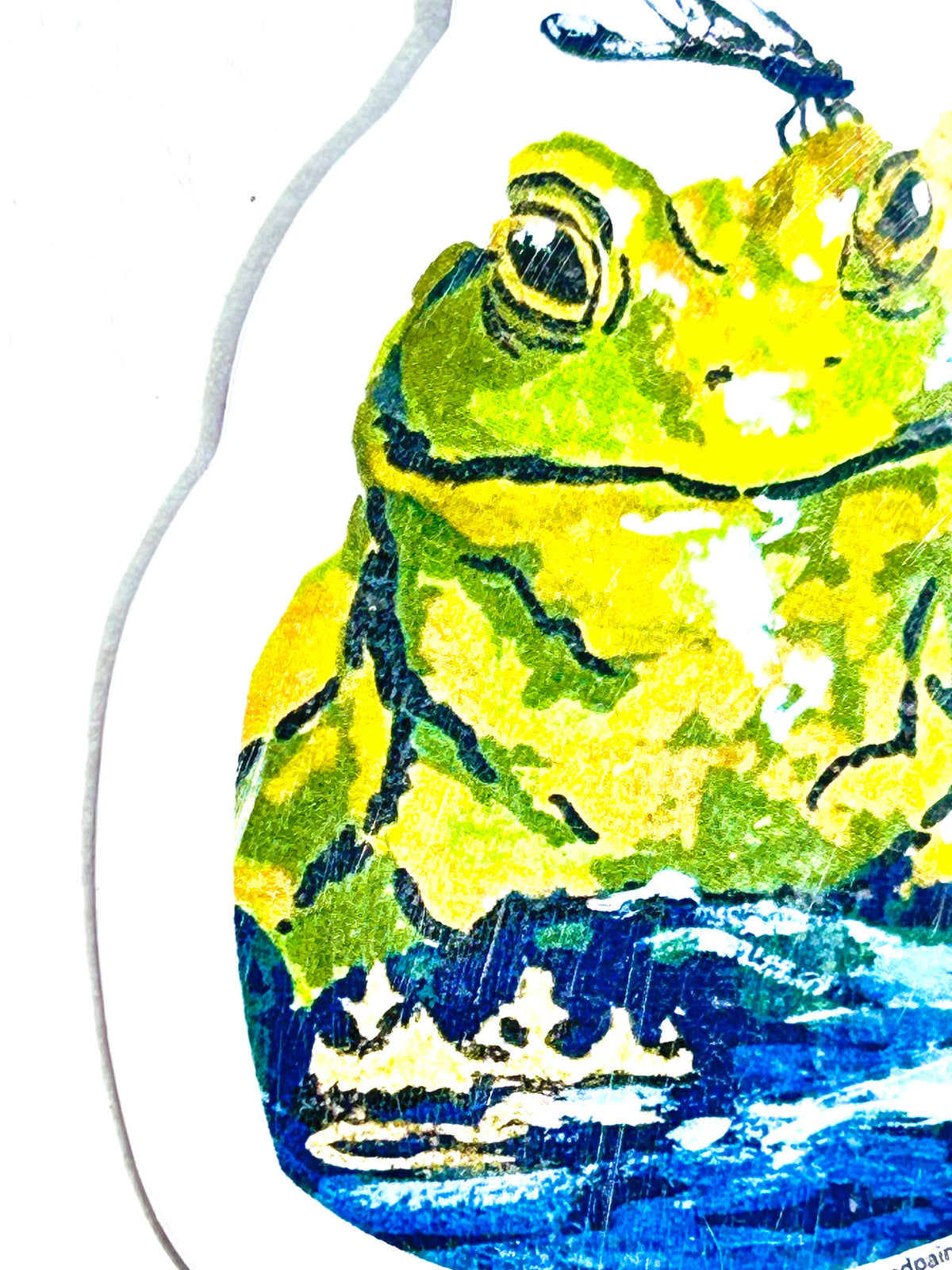 Side detail of Mind Your Business vinyl sticker showing the green frog, dragonfly, and water artwork
