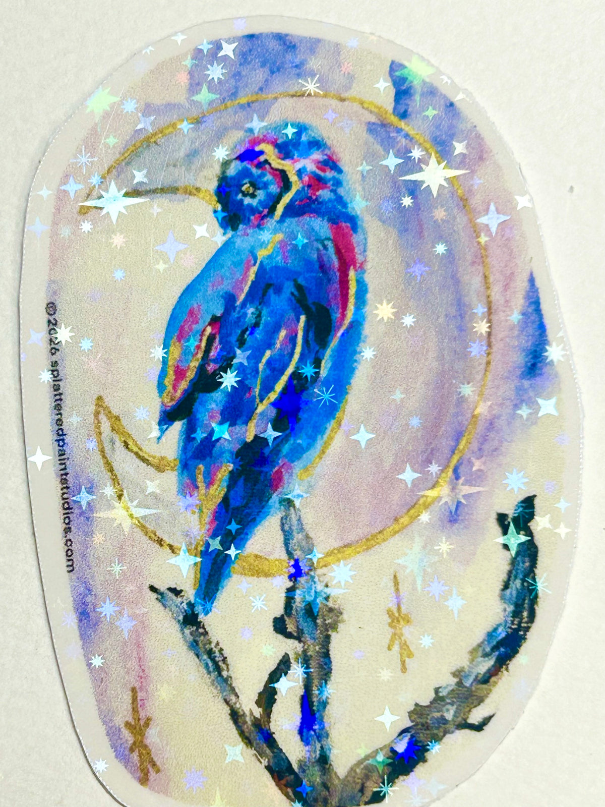 Moonbound Sentinel 3-inch holographic vinyl art sticker featuring a vivid blue bird surrounded by a crescent moon and reflective stars