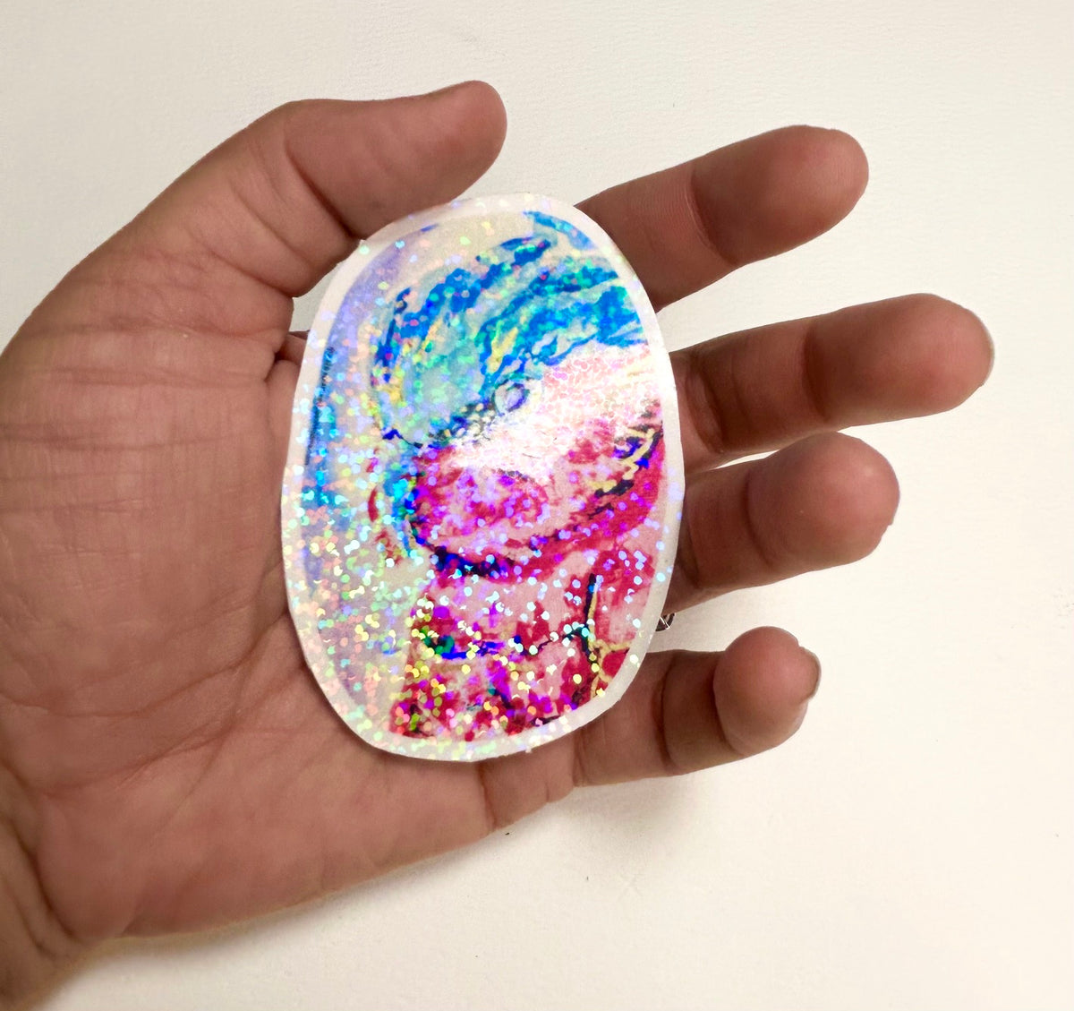 Nebula Regent 3-inch holographic vinyl sticker held in hand to show size and reflective finish