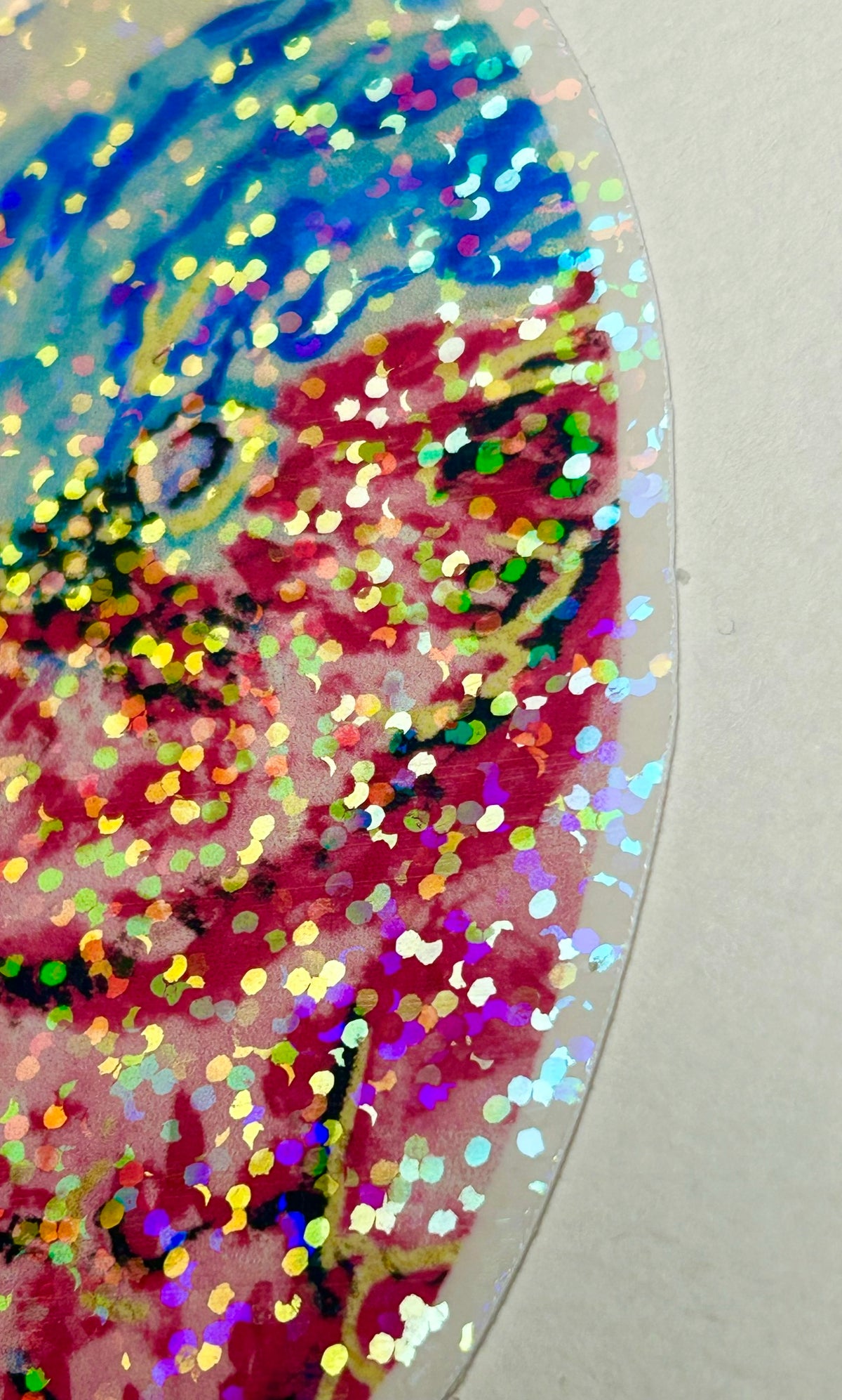 Close-up of Nebula Regent holographic vinyl sticker showing the colorful reflective glitter and bird artwork
