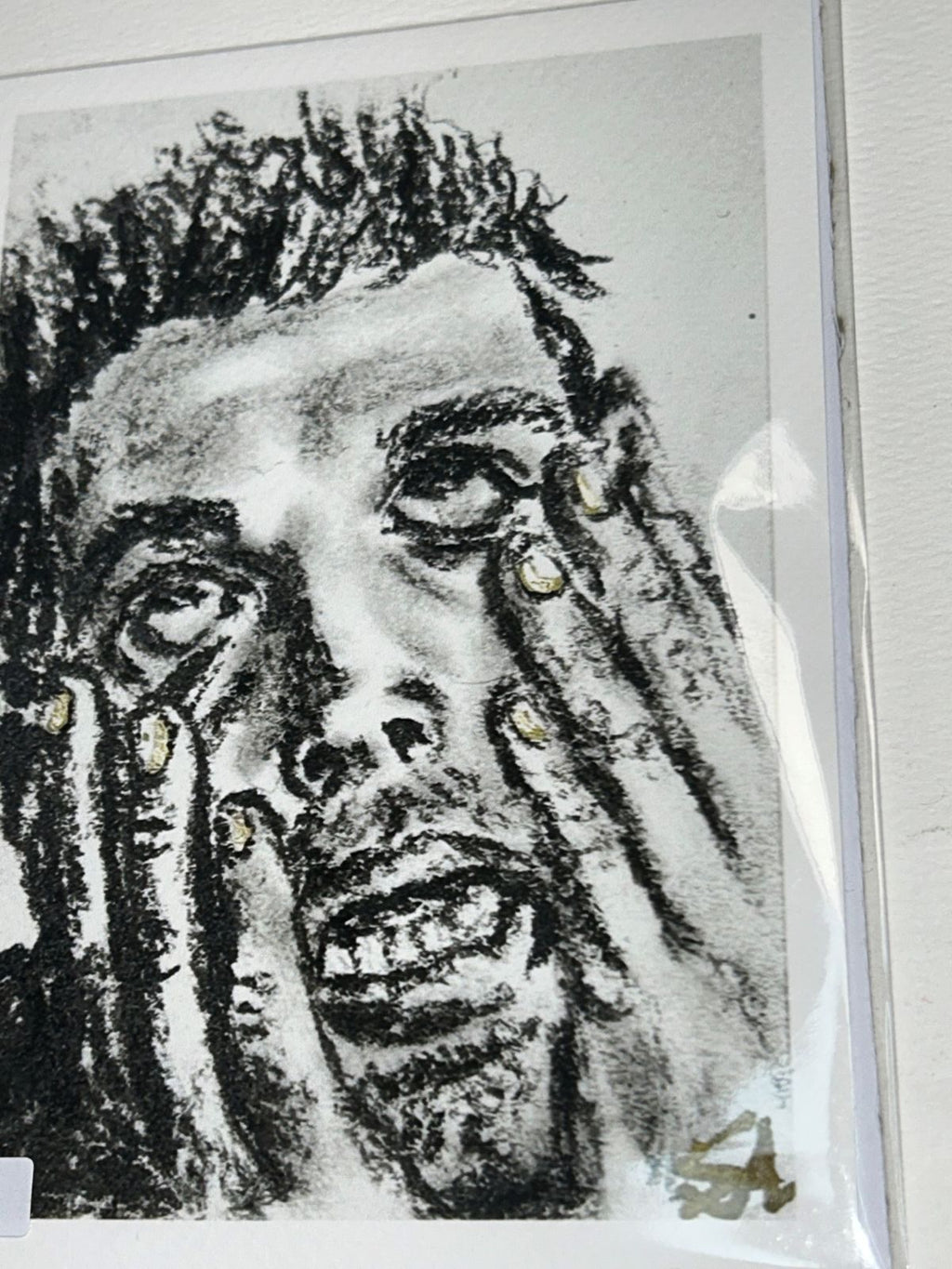 Close-up of Overwhelm charcoal art print showing an expressive portrait with hands framing the face and gold accents