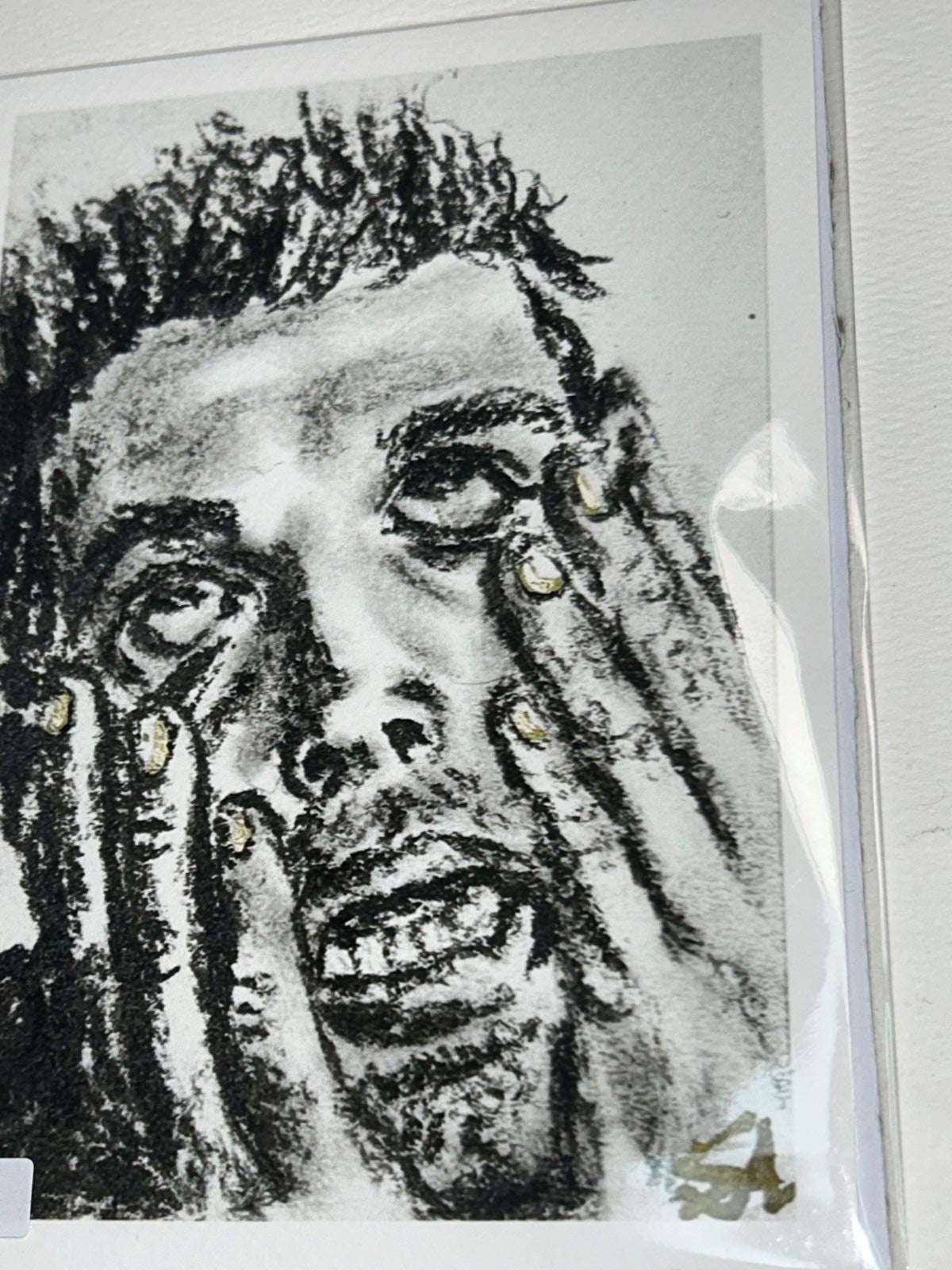 Close-up of Overwhelm charcoal art print showing an expressive portrait with hands framing the face and gold accents
