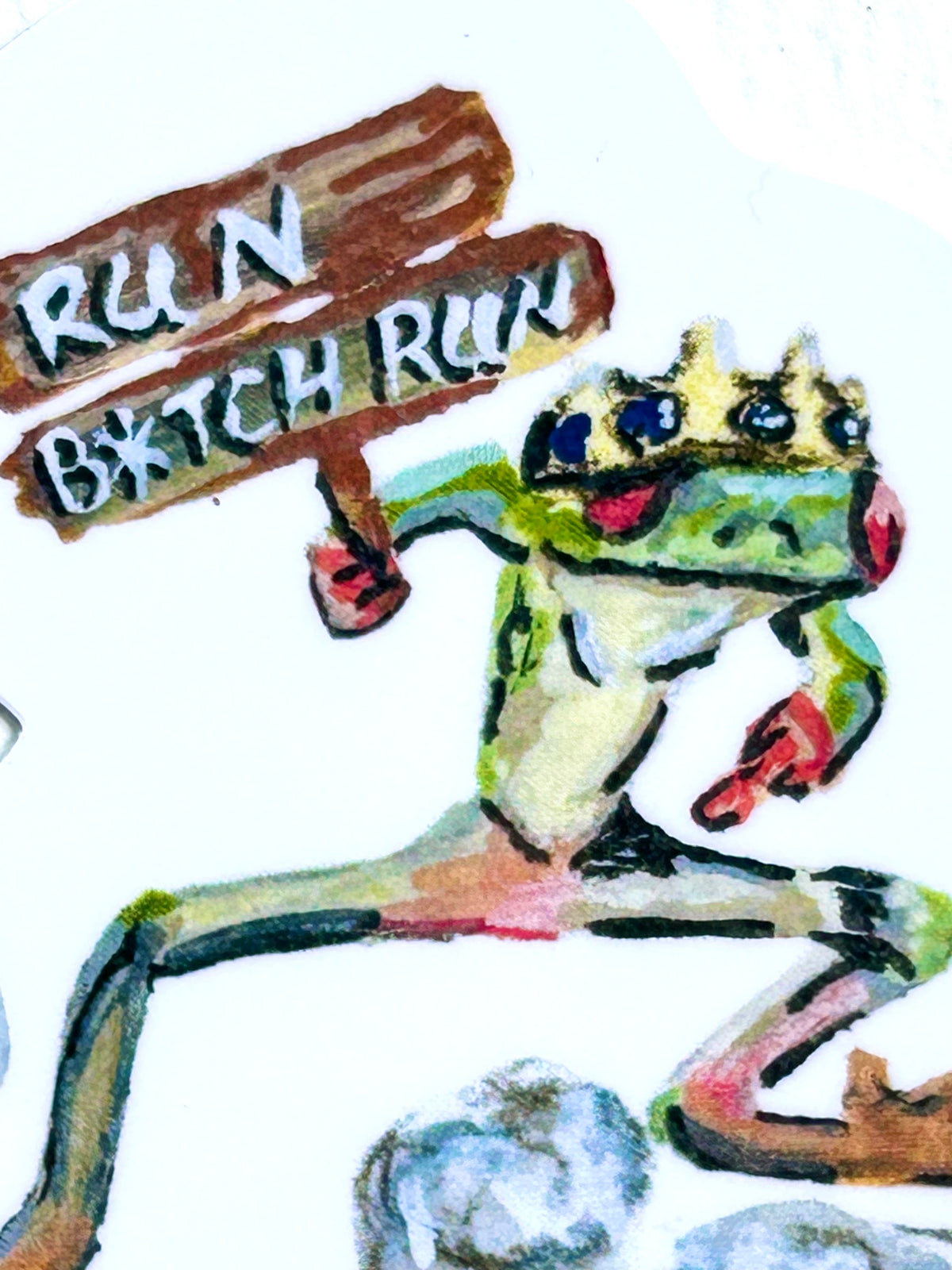 Close-up of Run B*tch Run vinyl sticker showing a crowned frog running with a wooden sign