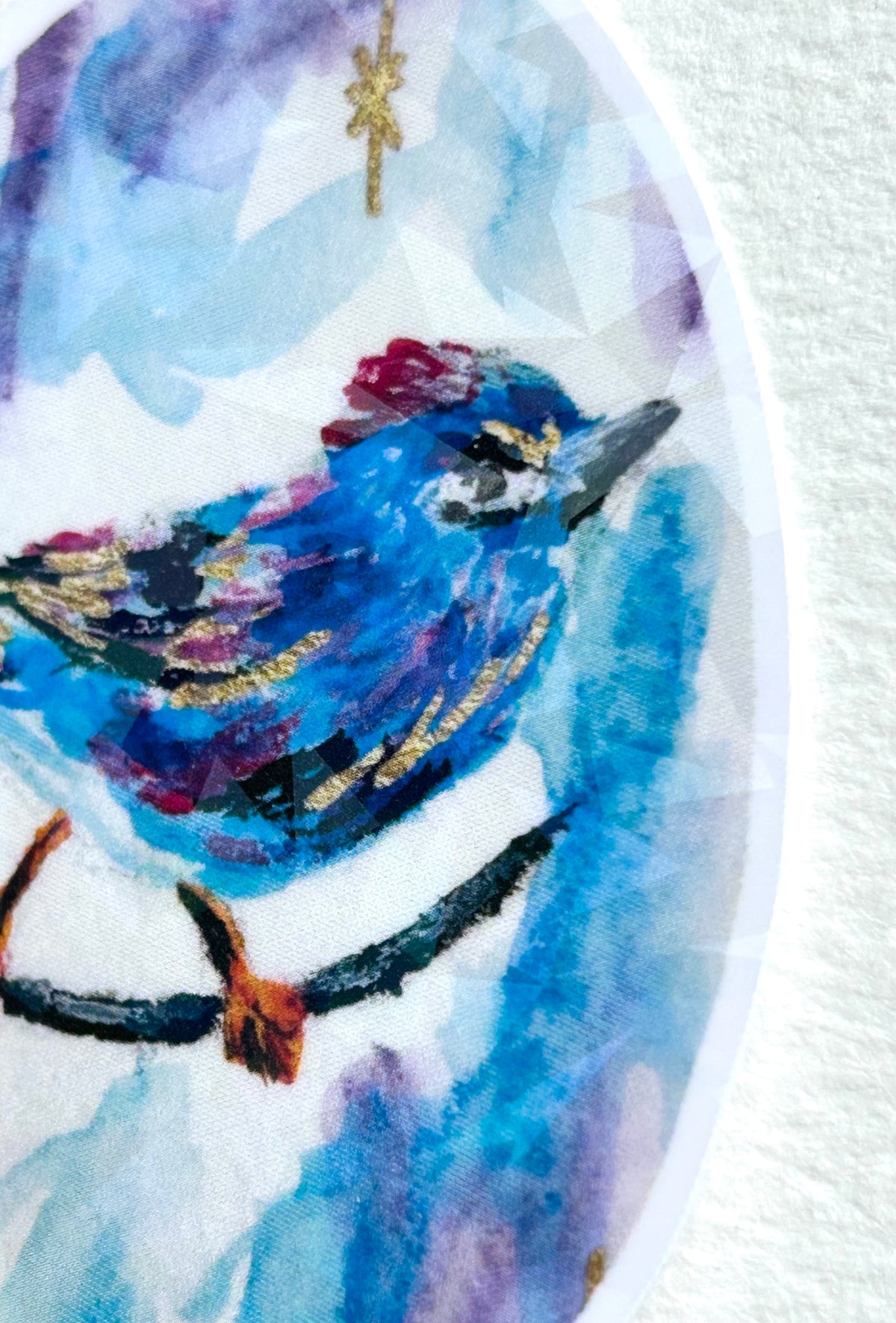 Detail view of Starglint vinyl sticker featuring a vibrant blue bird with gold and reflective accents
