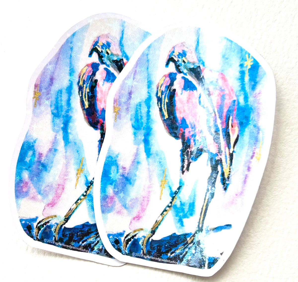 Two Starwake vinyl art stickers featuring a colorful pink and blue bird from the Starlit Aviary collection