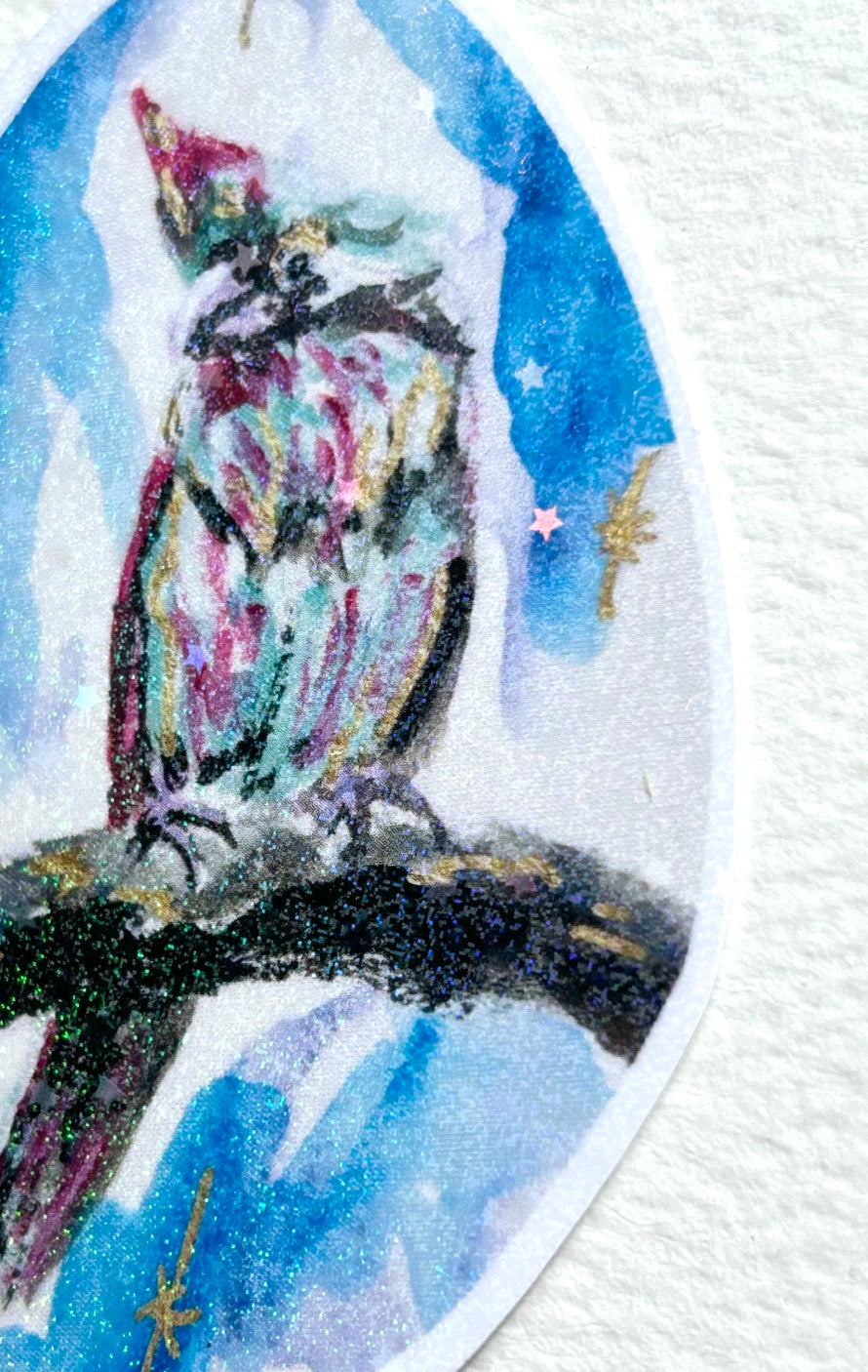 Detail view of Starward Vigil vinyl sticker featuring a colorful parrot perched on a branch