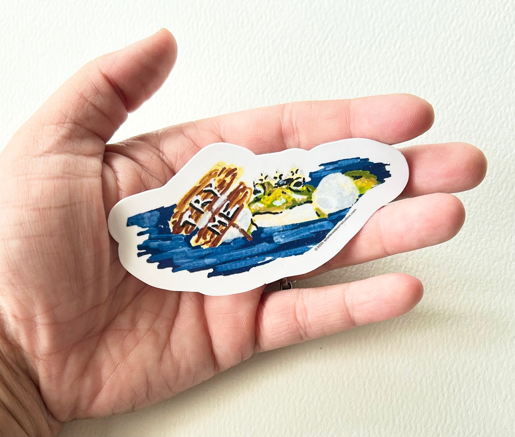 Try Me 3-inch vinyl frog sticker held in hand to show size and scale