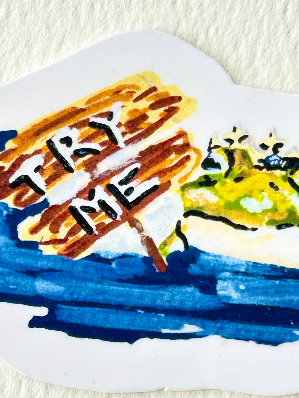 Close-up of Try Me vinyl sticker showing a crowned frog beside a hand-painted Try Me sign