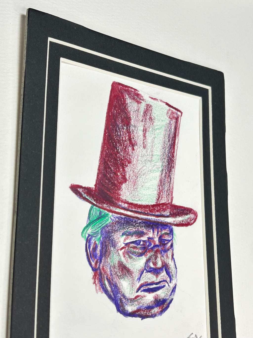Angled view of Under the Hat original colored pencil portrait with red top hat and black and white 5x7 mat