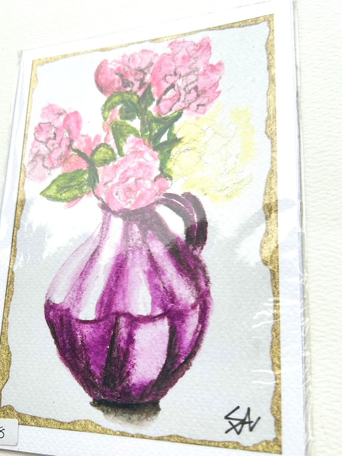 Angled view of Violet Offering 5x7 art print featuring pink flowers in a violet vase with gold border