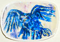 Close-up of Voiding Radiance laminated vinyl sticker featuring a blue bird with gold details and holographic stars.