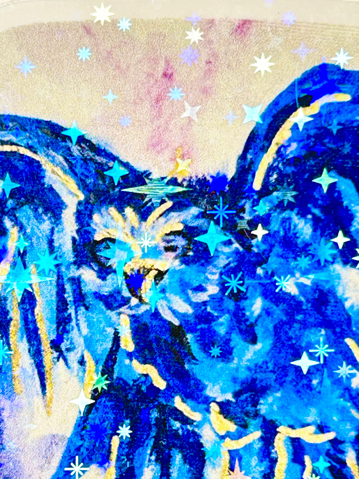 Close-up of Voiding Radiance laminated vinyl sticker featuring a vivid blue bird with gold details and holographic star accents.